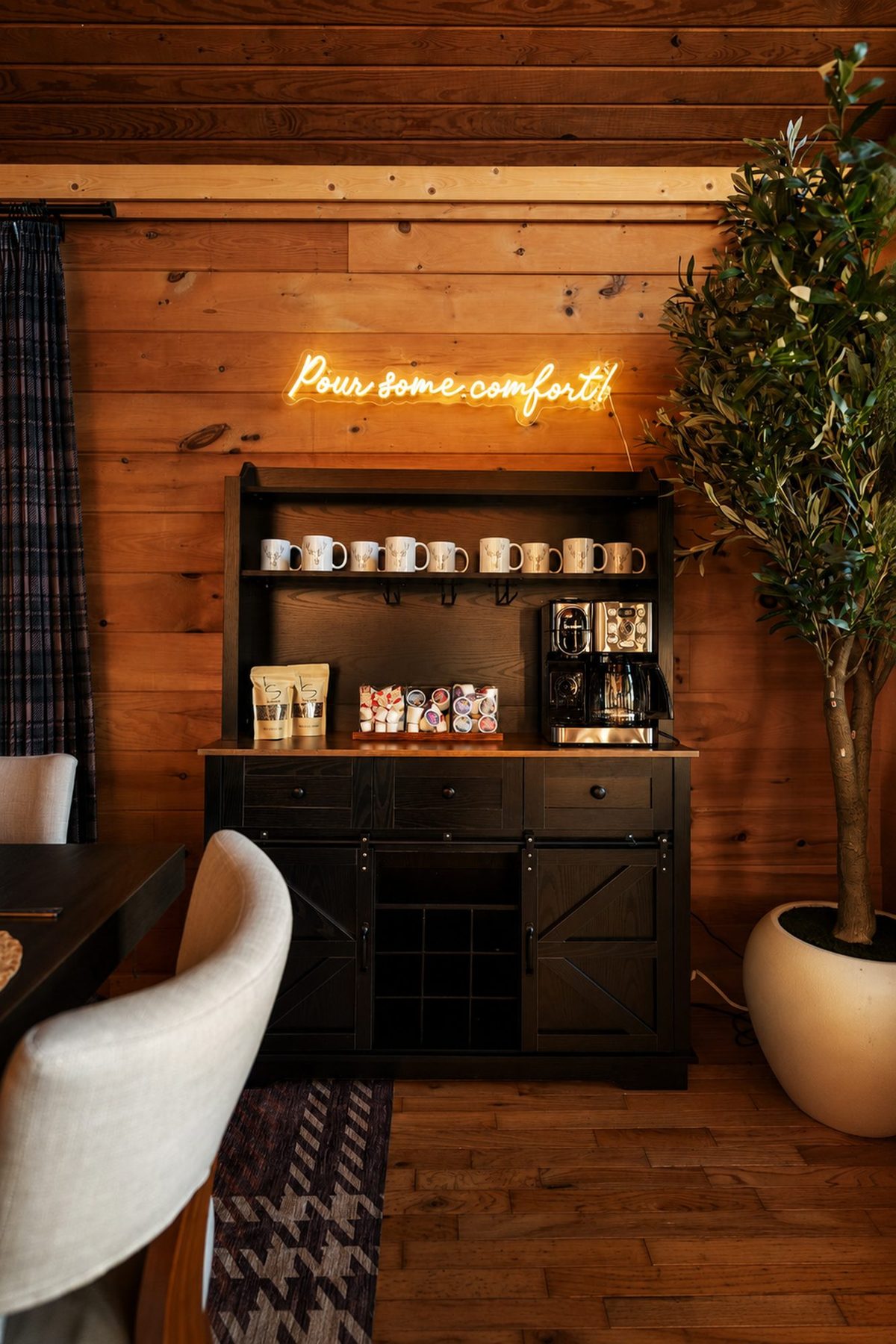 Coffee bar with a neon script sign, open shelving and a leather barstool