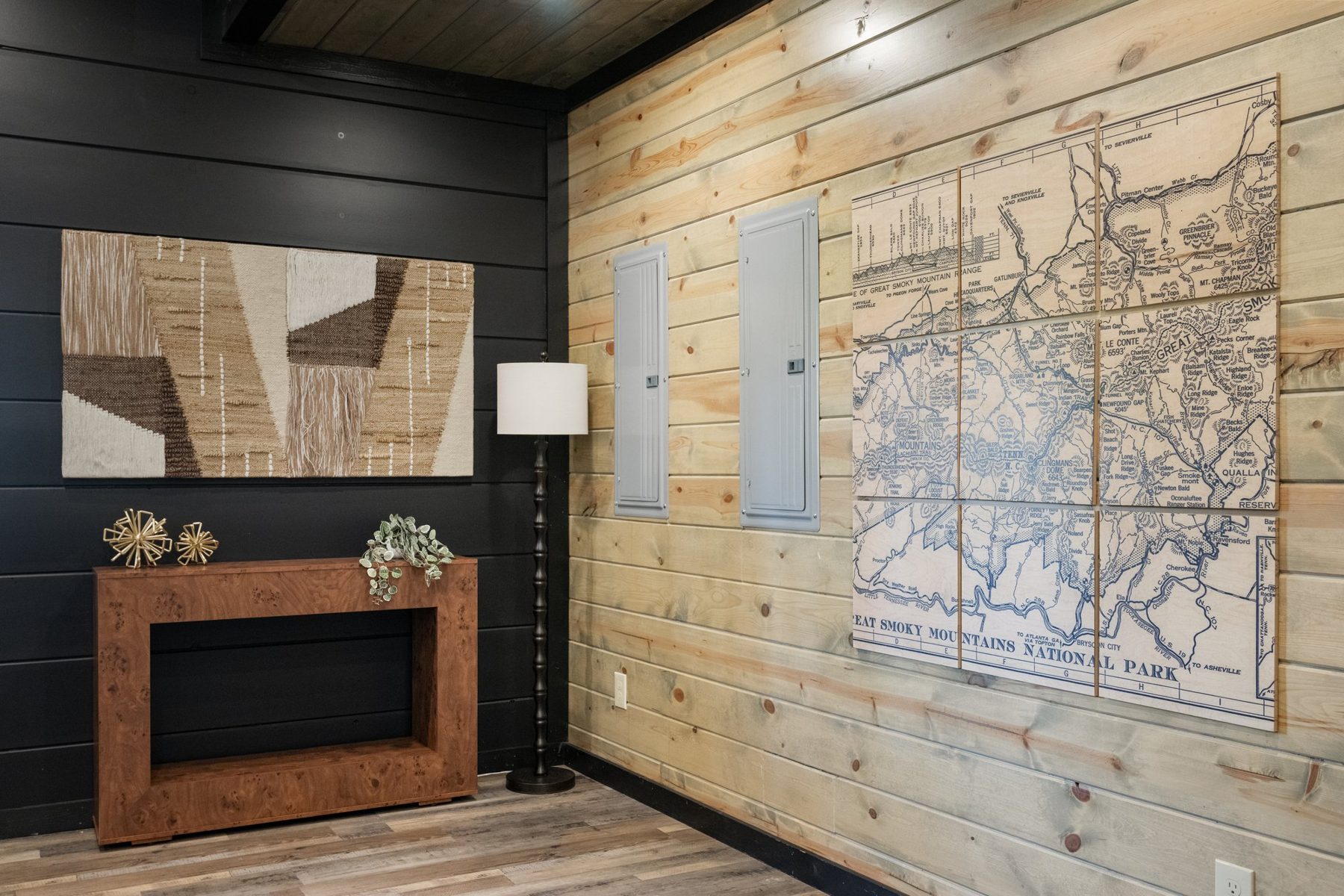Entry wall in black shiplap and knotty pine with a vintage Smoky Mountains map, abstract timber artwork and a burl console