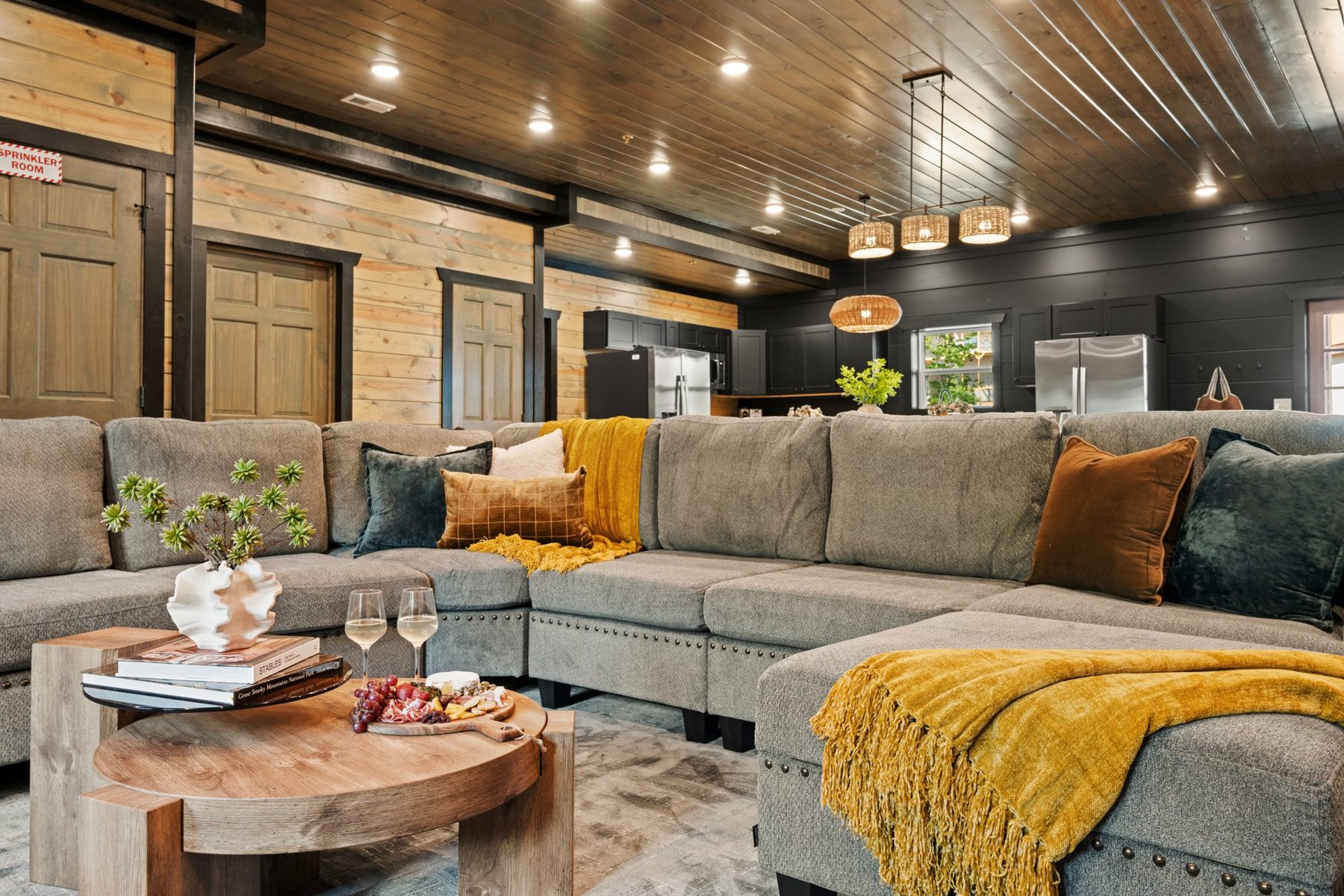 Sectional and round timber coffee table styled with a charcuterie board and wine