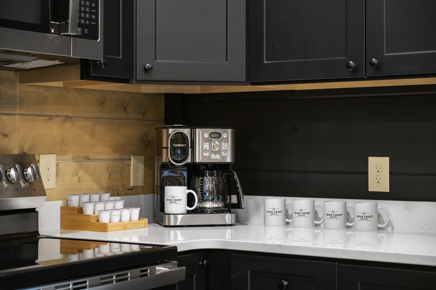 Coffee station with a row of Iron Crest Social mugs against a reclaimed pine backsplash