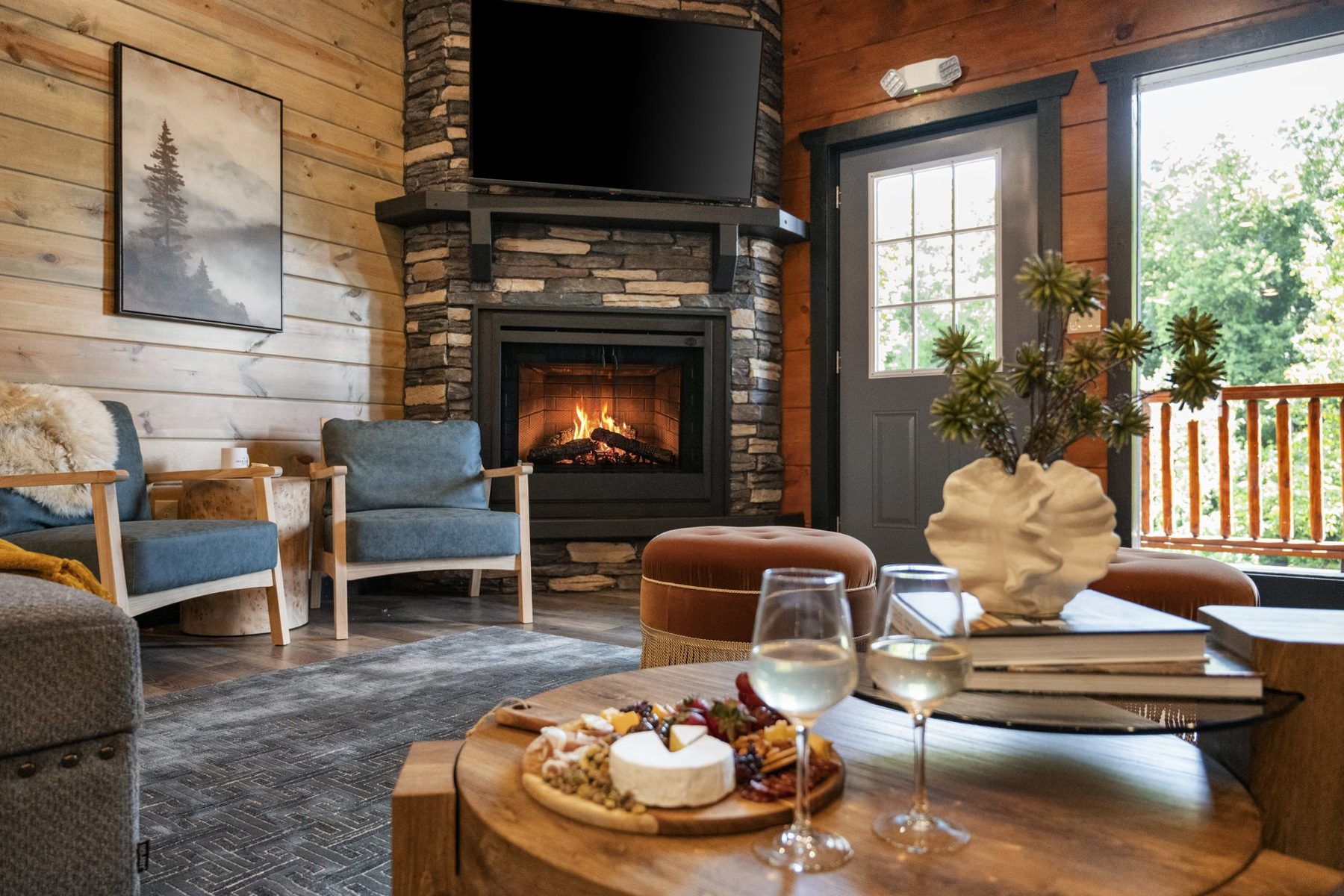 Fireside nook with blue armchairs, a sheepskin throw and a stacked-stone fireplace