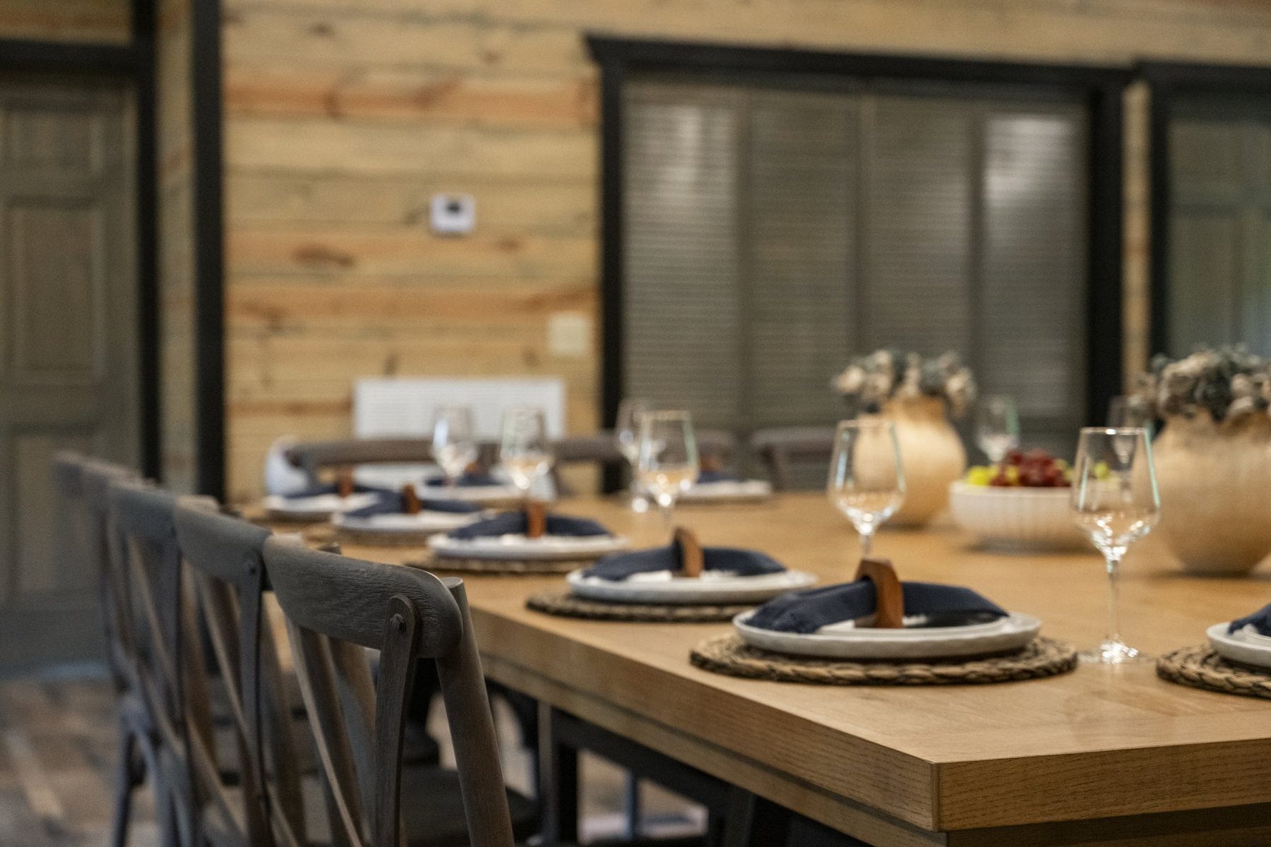 Table set with woven chargers, navy napkins and stemware