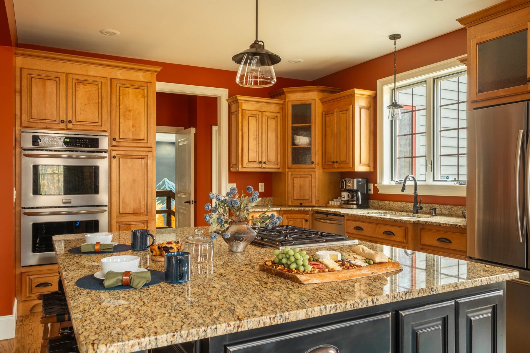 Kitchen with honey maple cabinets, granite island and an entertaining spread