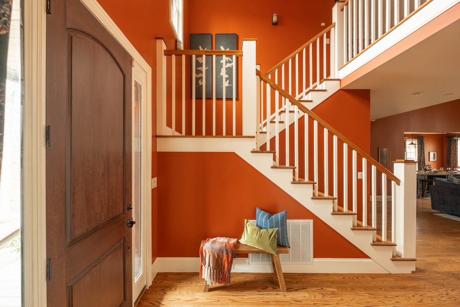 Entry hall with rust walls, a white timber staircase and a reading nook