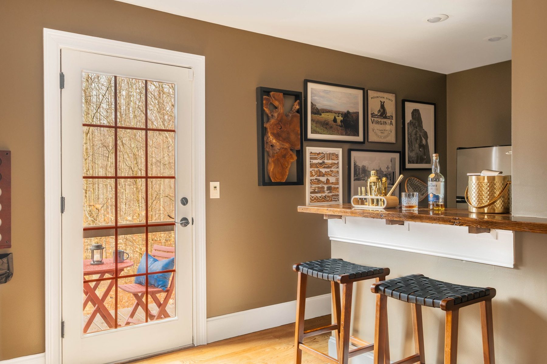 Loft bar with framed prints, woven stools and a walnut counter