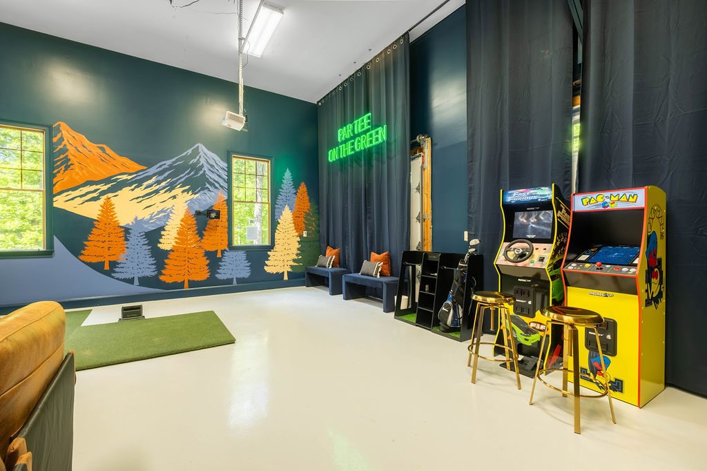 Games room with a hand-painted mountain mural, neon sign and golf simulator
