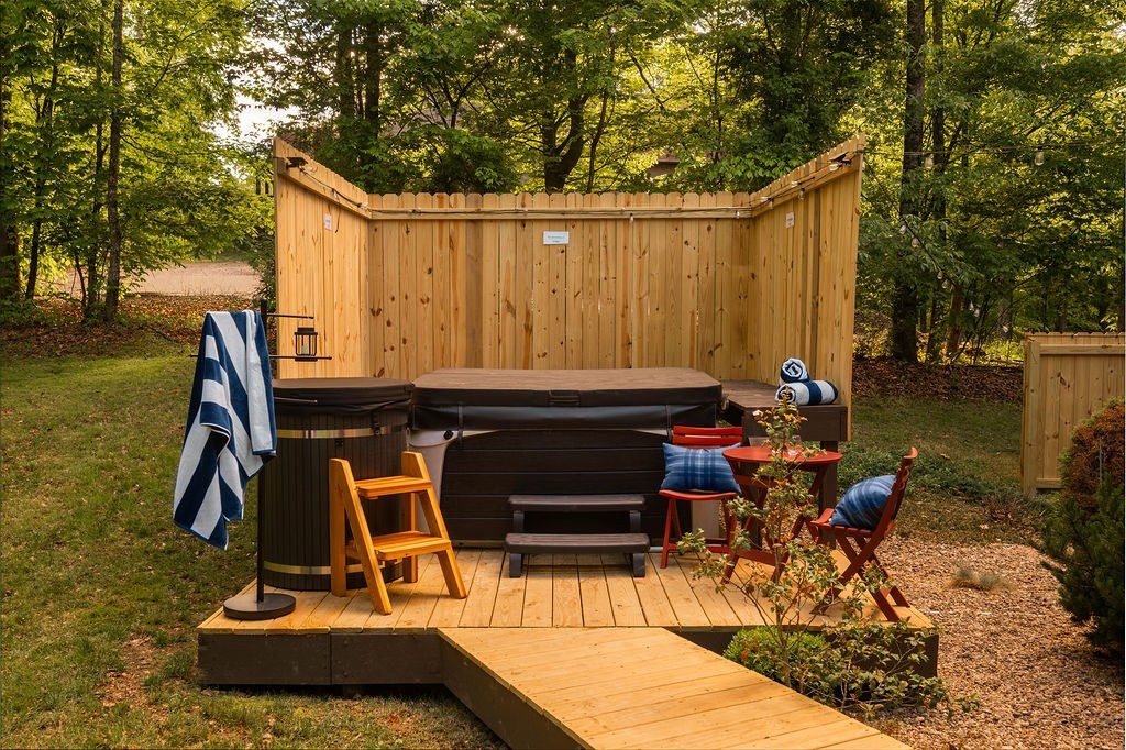 Hot tub and cold plunge on a timber deck behind a cedar privacy screen