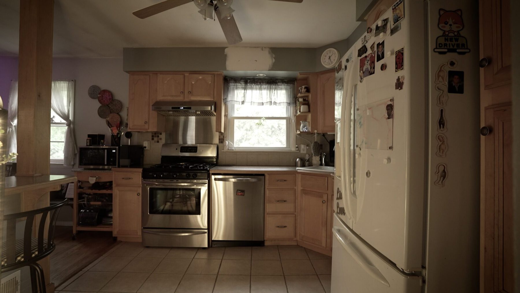 Before: the original kitchen with honey-maple cabinets, tiled floor and a post in the room
