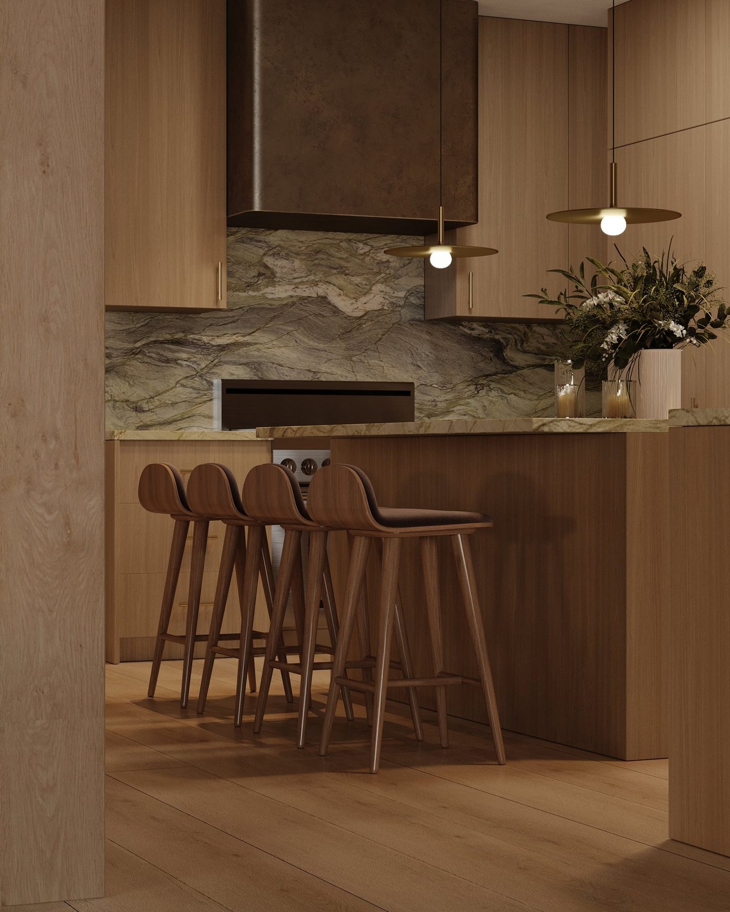 Walnut counter stools at the island beneath brass pendants, with the bronze-finish hood beyond